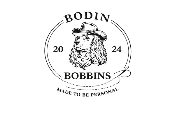 Logo of Bodin Bobbins with a spaniel wearing a cowboy hat and the text 'Made to be Personal'. established in 2024